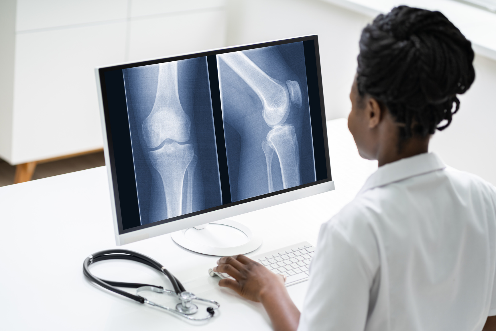 Surgeon Doctor Looking At Knee Xray Bone Scan
